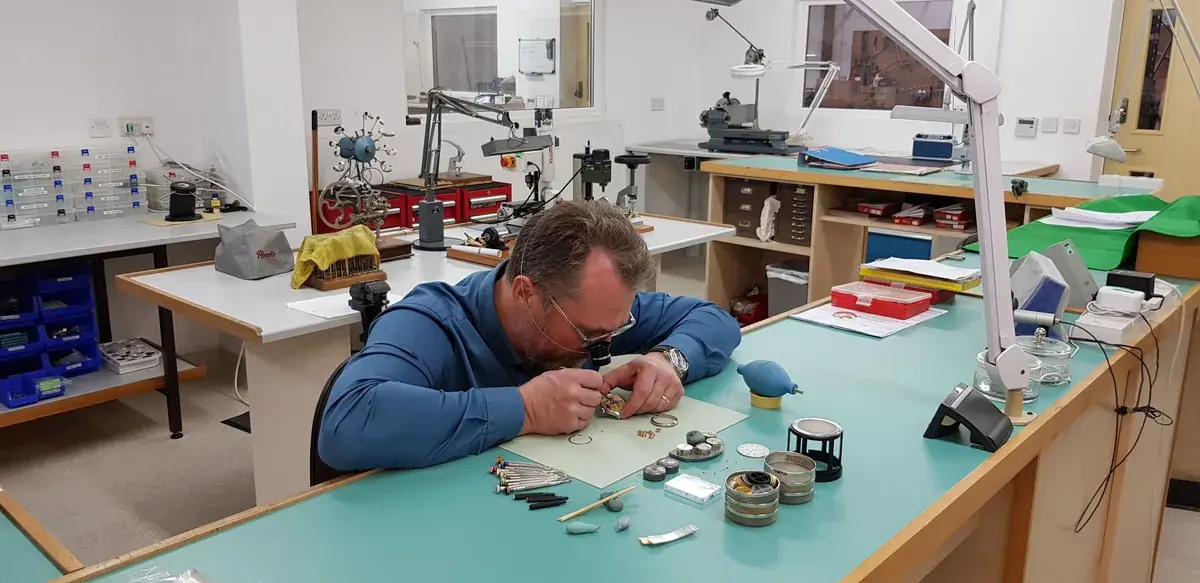 The Garrick workshop in Norfolk: a watchmaker at his bench among the tools and lathes
