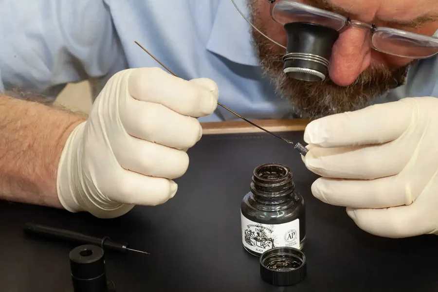 Ink-filling the engraved numerals of a dial by hand