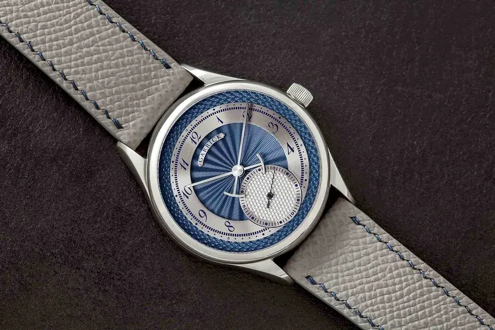 A blue engine-turned S7 dial on a grey strap